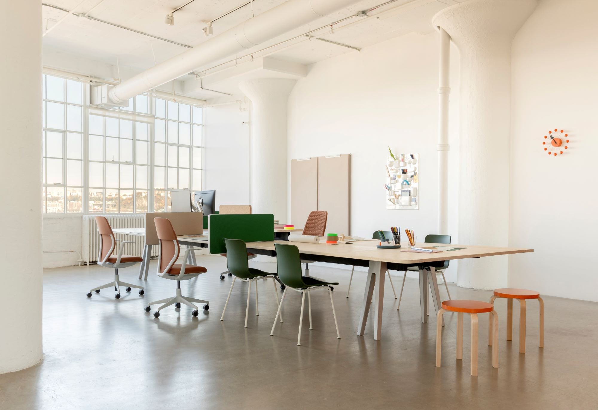 Modern office space with desks, chairs, and a large window.