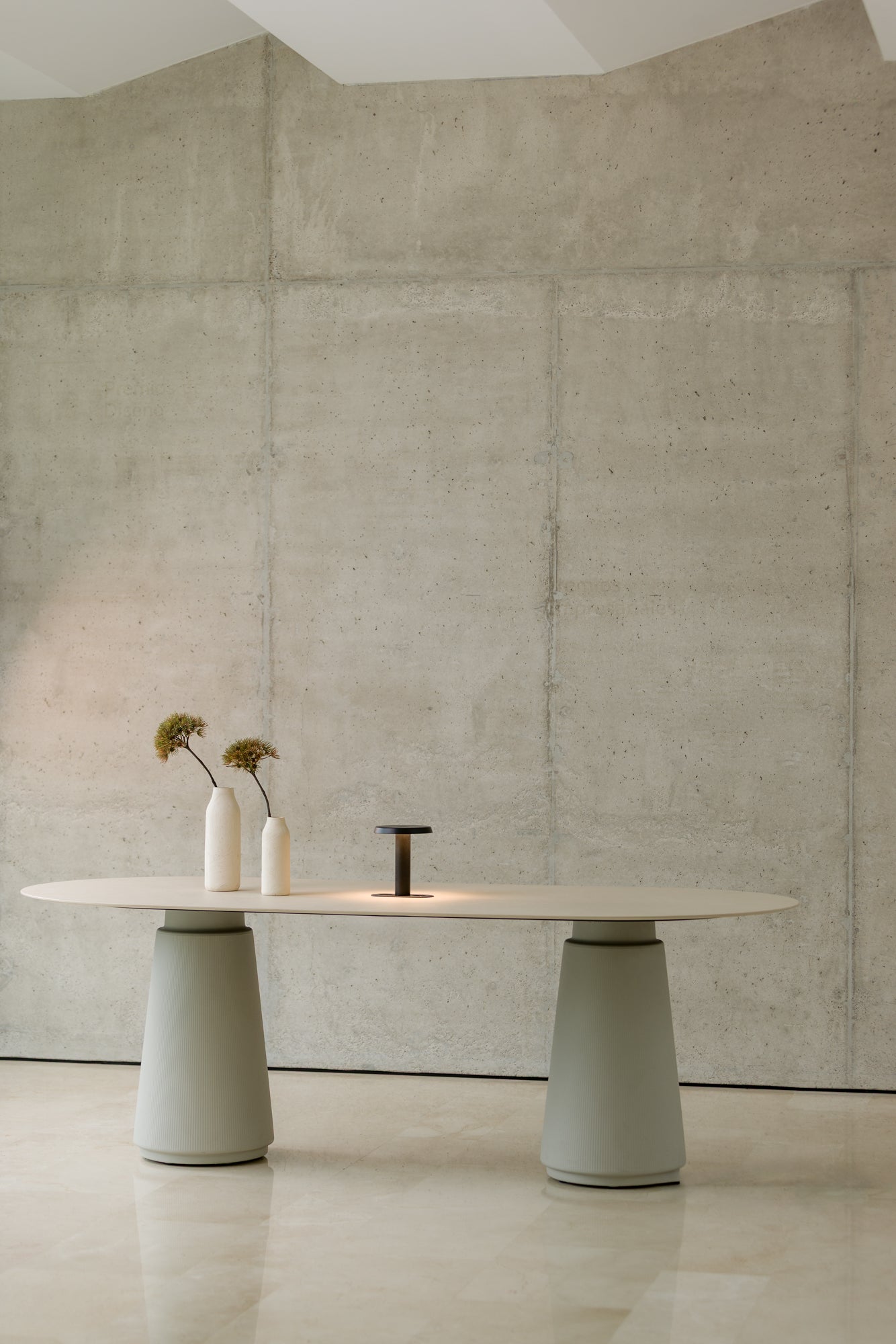 Modern dining table with a minimalist design against a concrete wall.