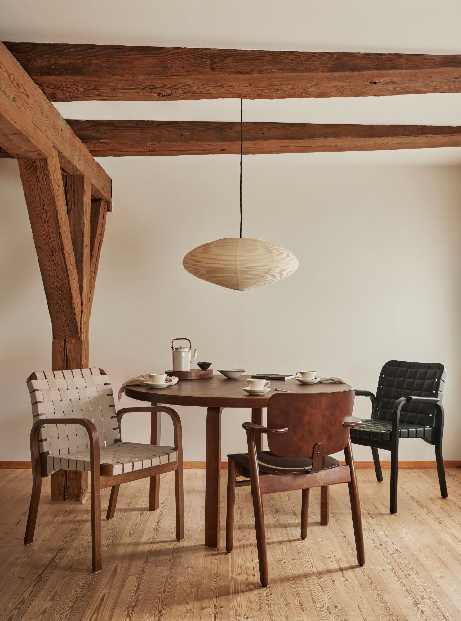 Dining area with wooden table and chairs in a room with wooden beams.