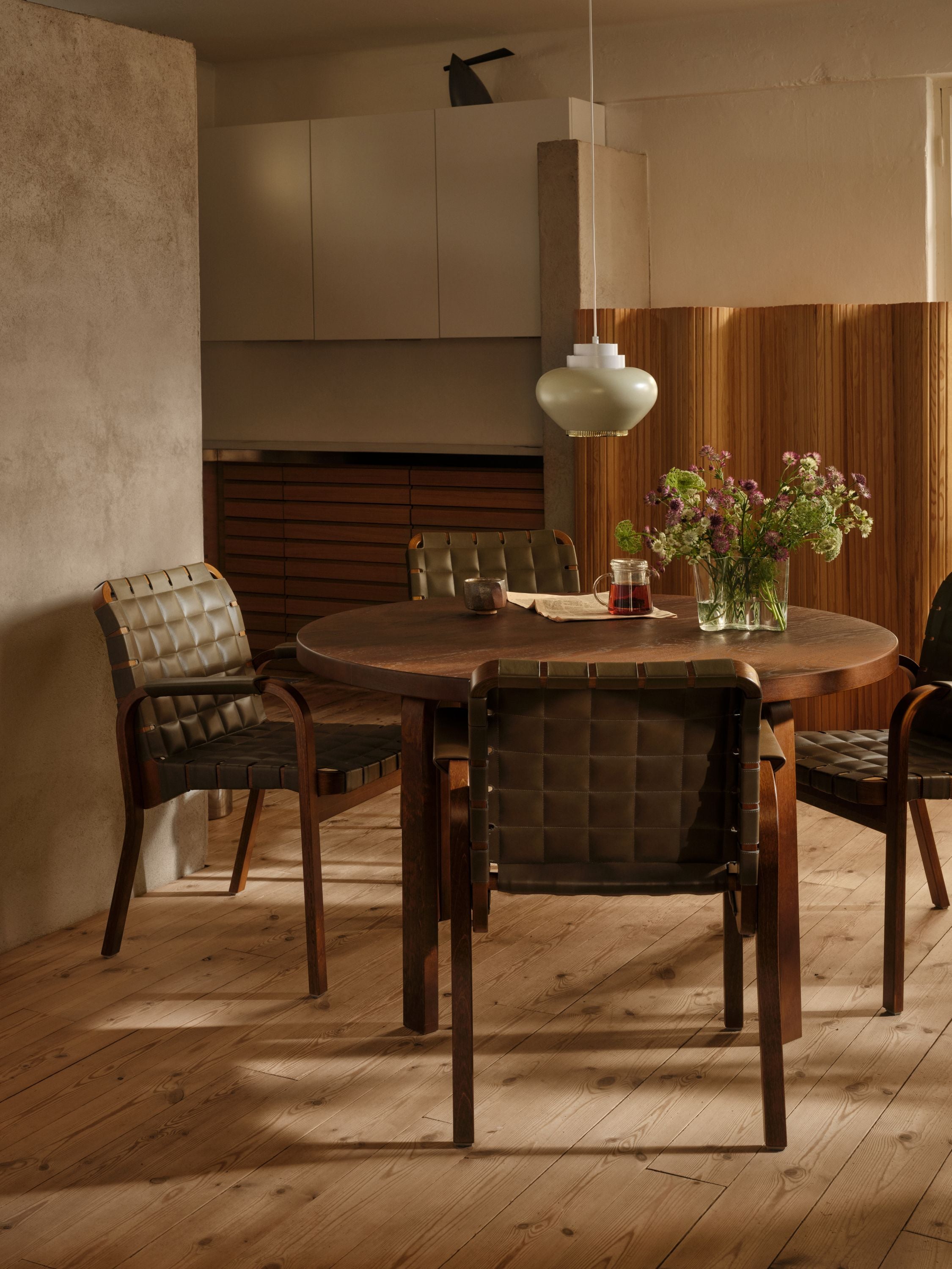 Dining area with wooden table and chairs in a warm-toned room.