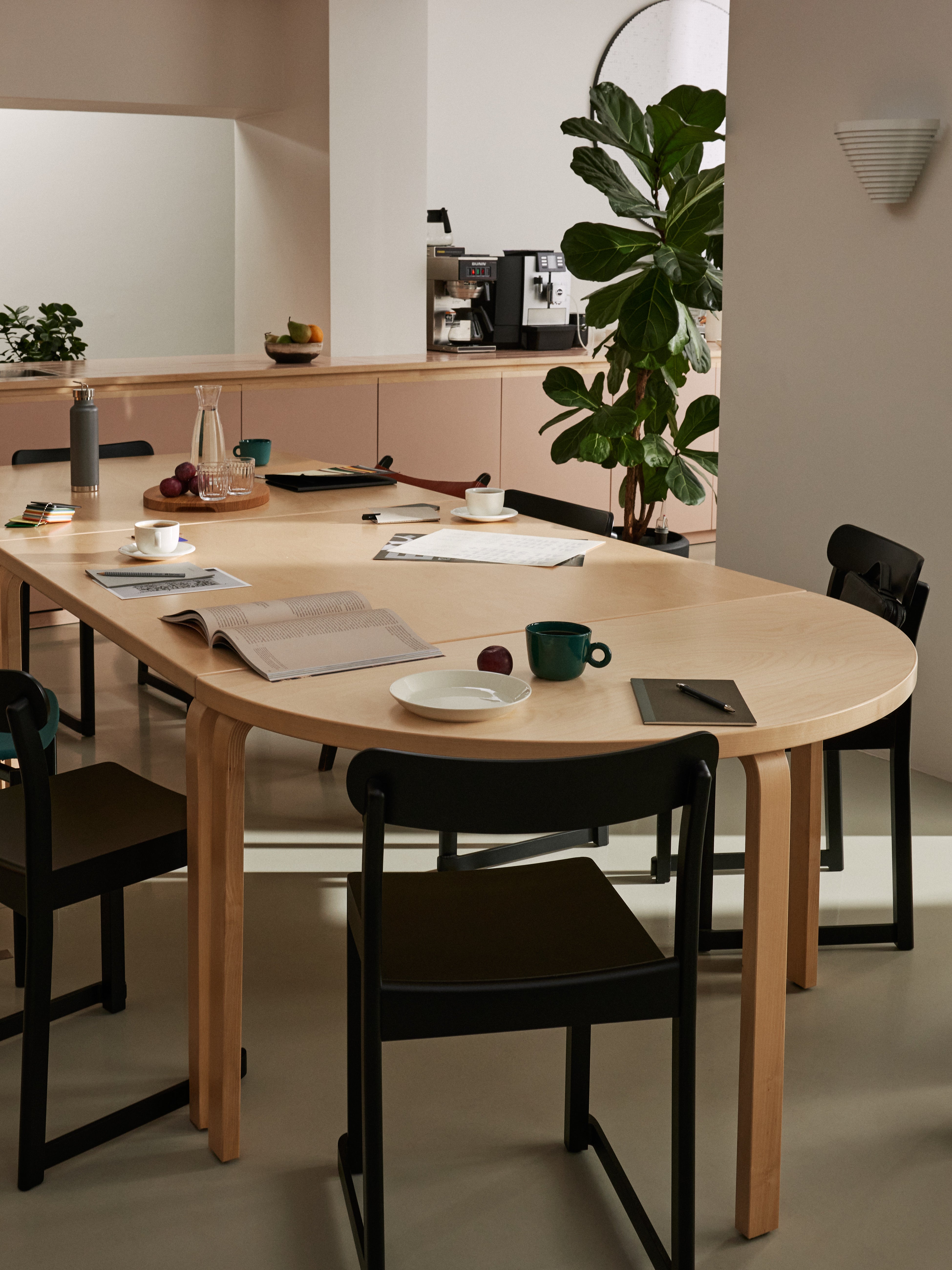 Dining area with a wooden table and black chairs in a modern kitchen.
