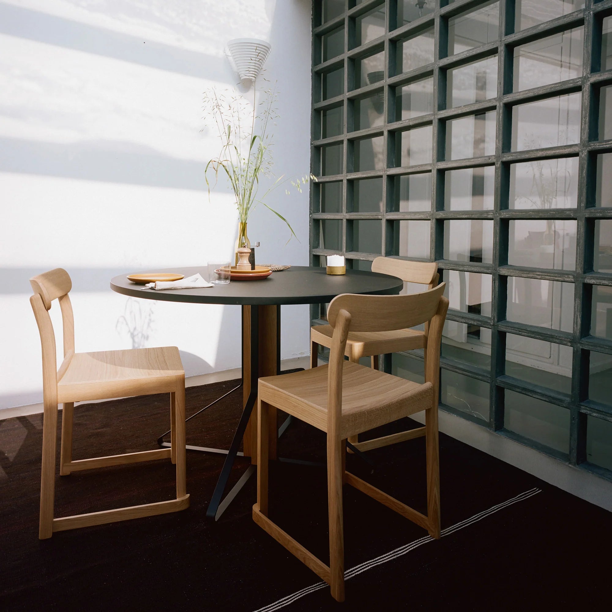 Dining area with a round table and wooden chairs in a modern interior setting.