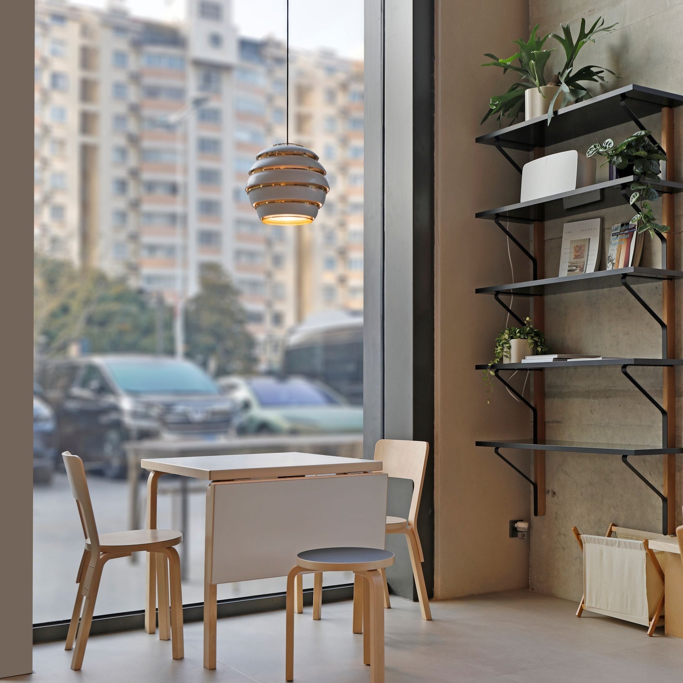 Modern room with a table and chairs near a large window with cityscape view.