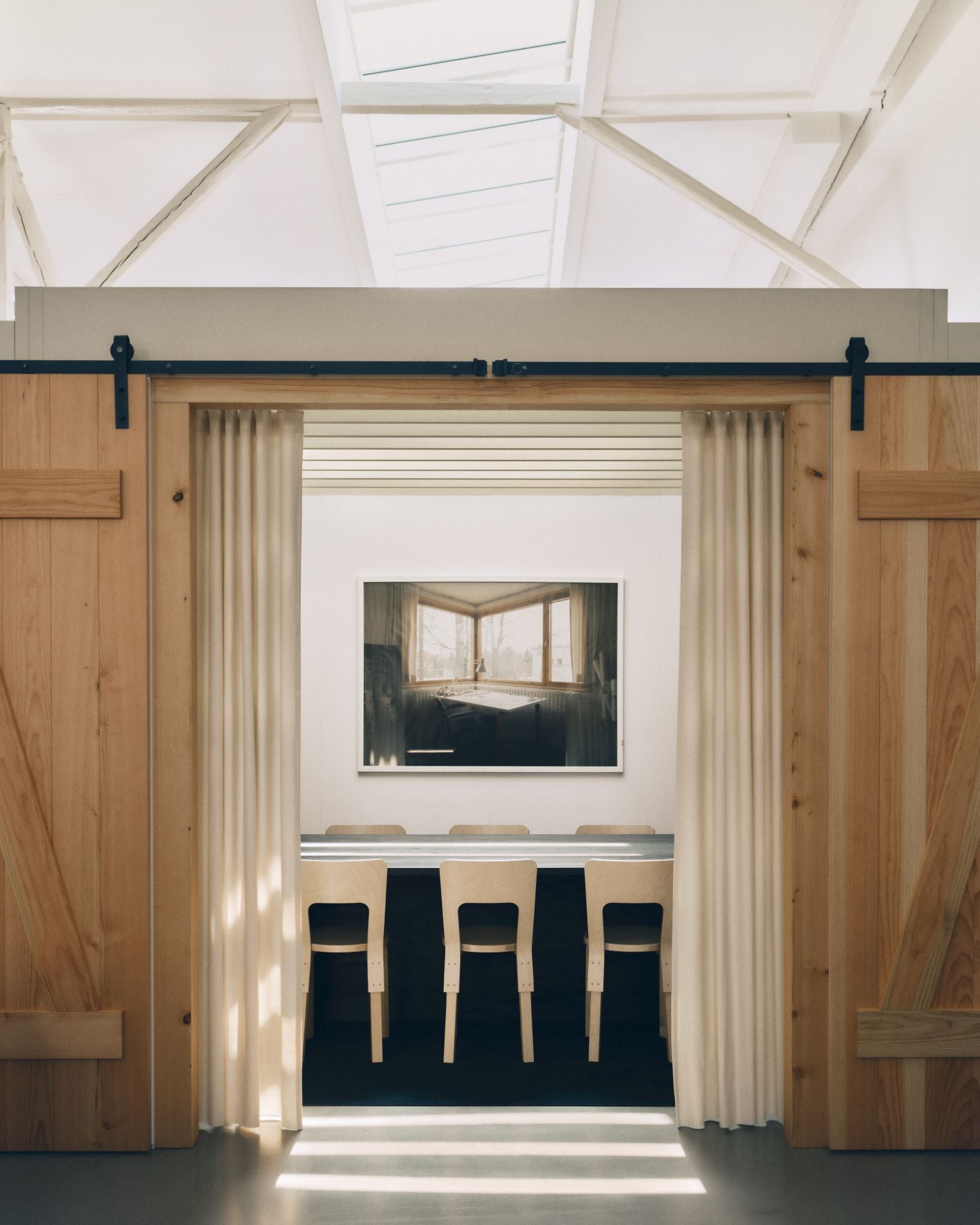 Modern interior with wooden sliding doors, white walls, and a television mounted on the wall.