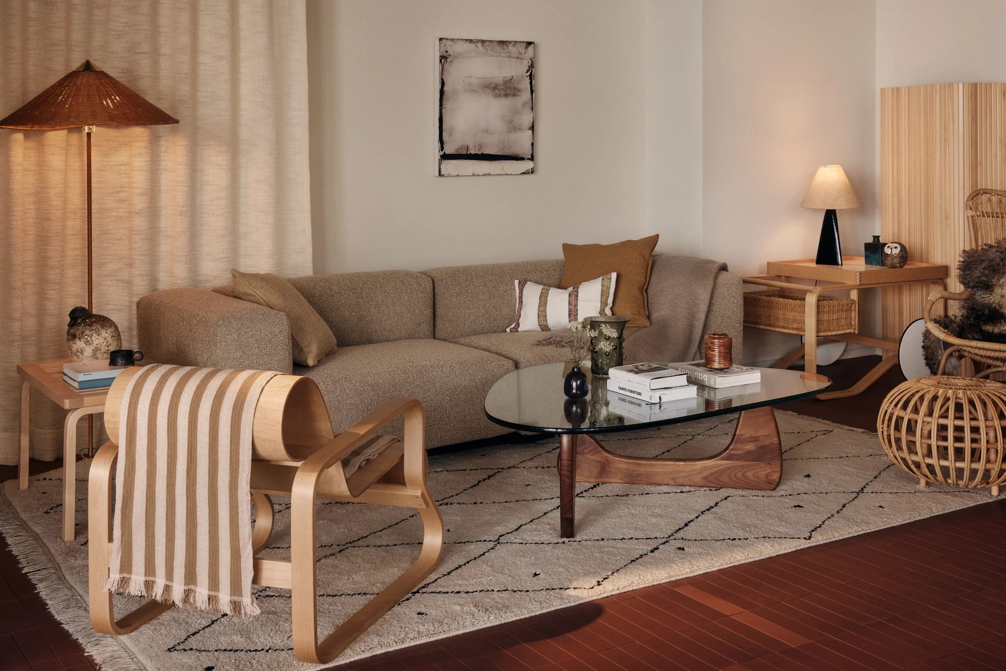 Living room with a brown sofa, glass coffee table, and wooden chairs.