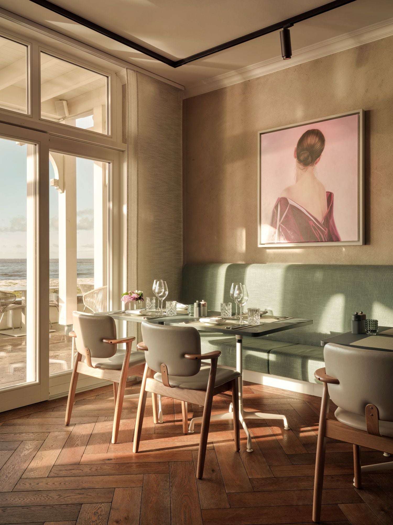 Modern dining room with large windows, wooden floor, and a painting on the wall.
