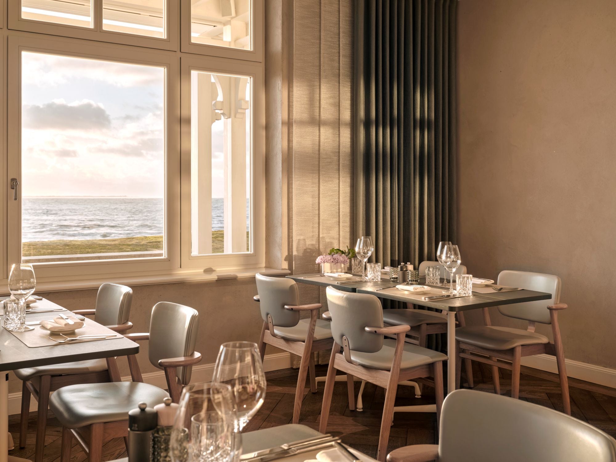 Dining area with large windows overlooking a scenic view of the ocean.