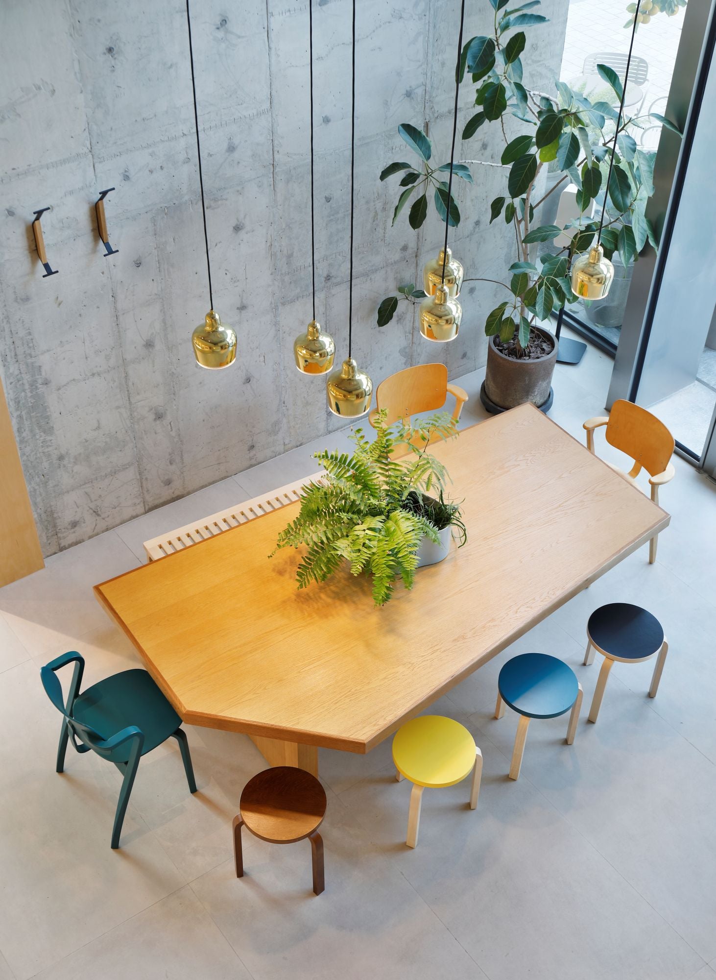 Modern dining area with a wooden table and colorful chairs in a bright room.