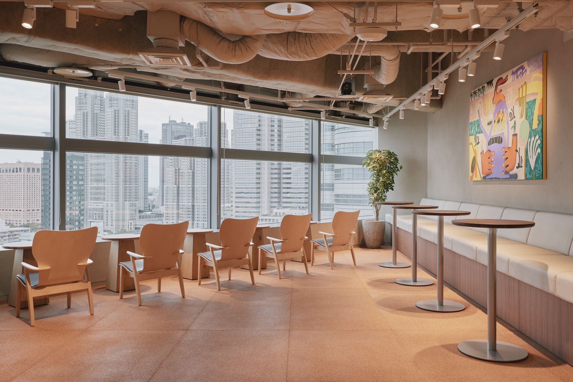 Modern office space with chairs, tables, and a cityscape view.
