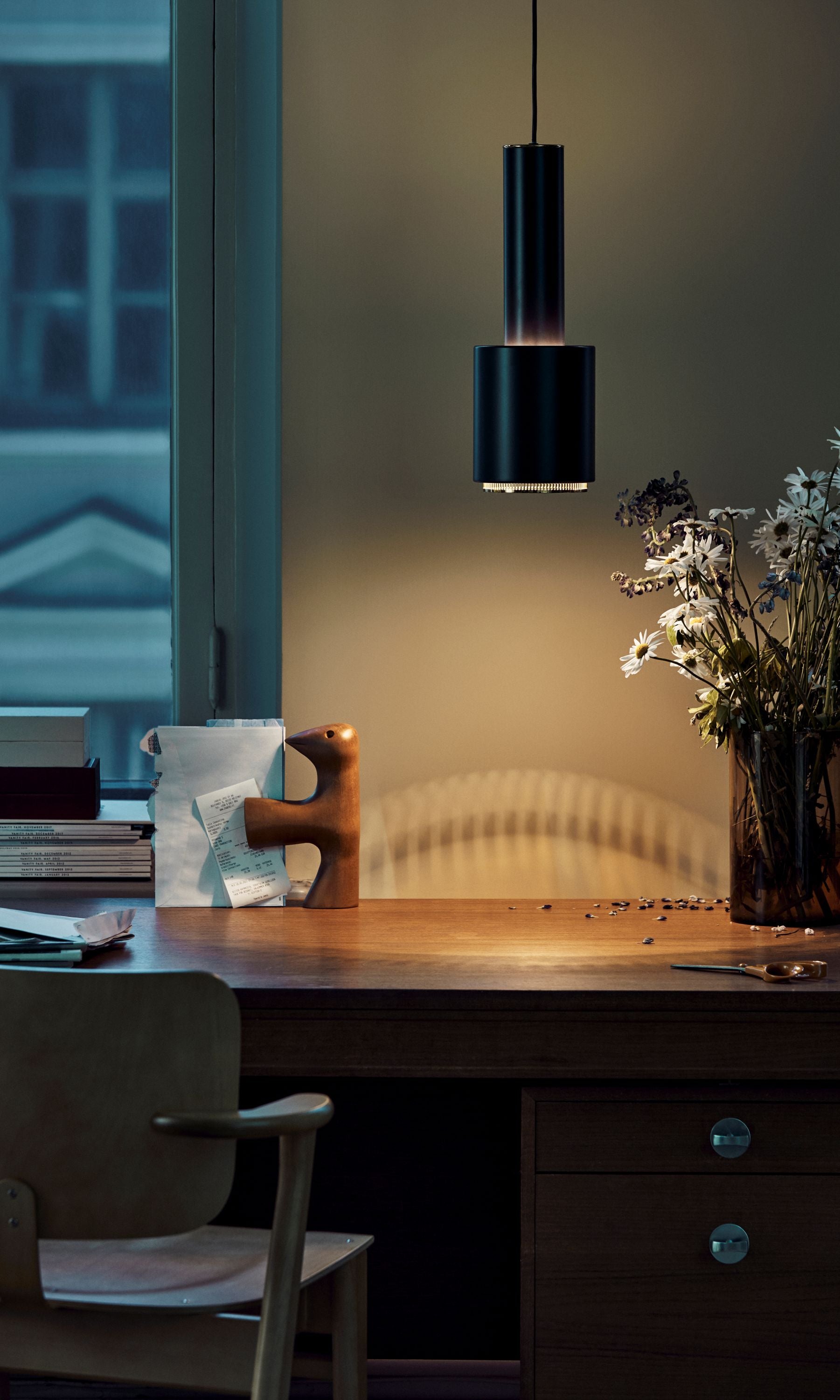 Modern interior with a wooden desk, chair, and decorative items.