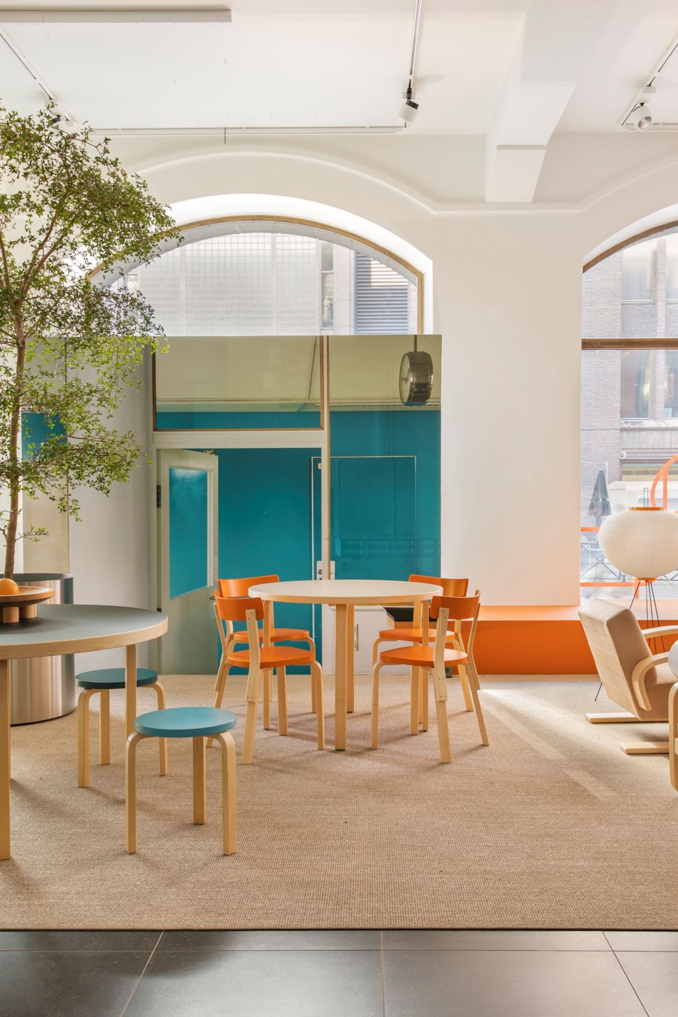 Modern office space with colorful furniture and large windows.