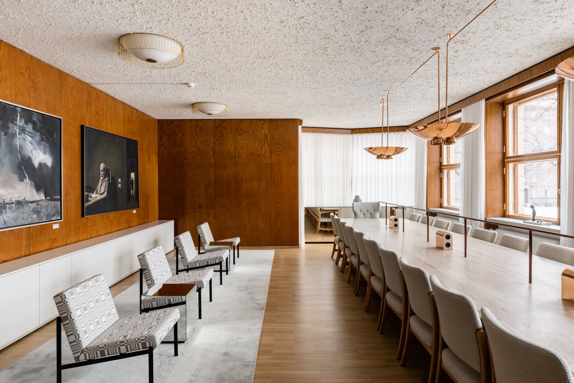 Modern office or meeting room with wooden walls, chairs, and large windows.