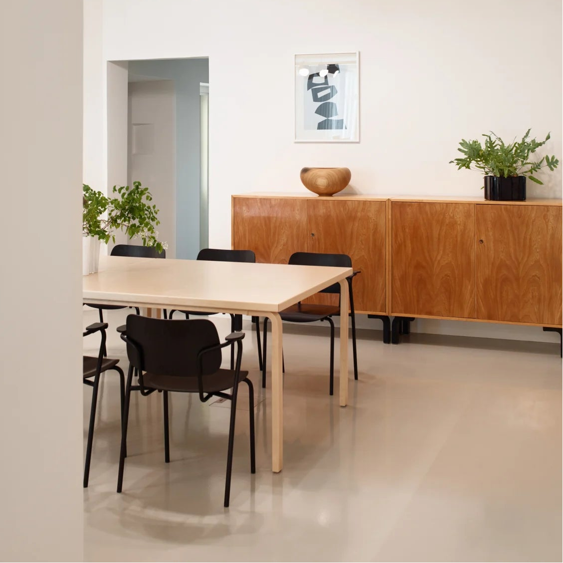 Modern office space with a wooden desk, chairs, and decorative elements.