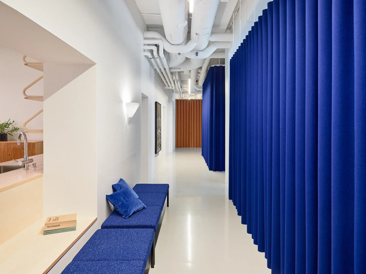 Modern office space with blue seating area and curtains.