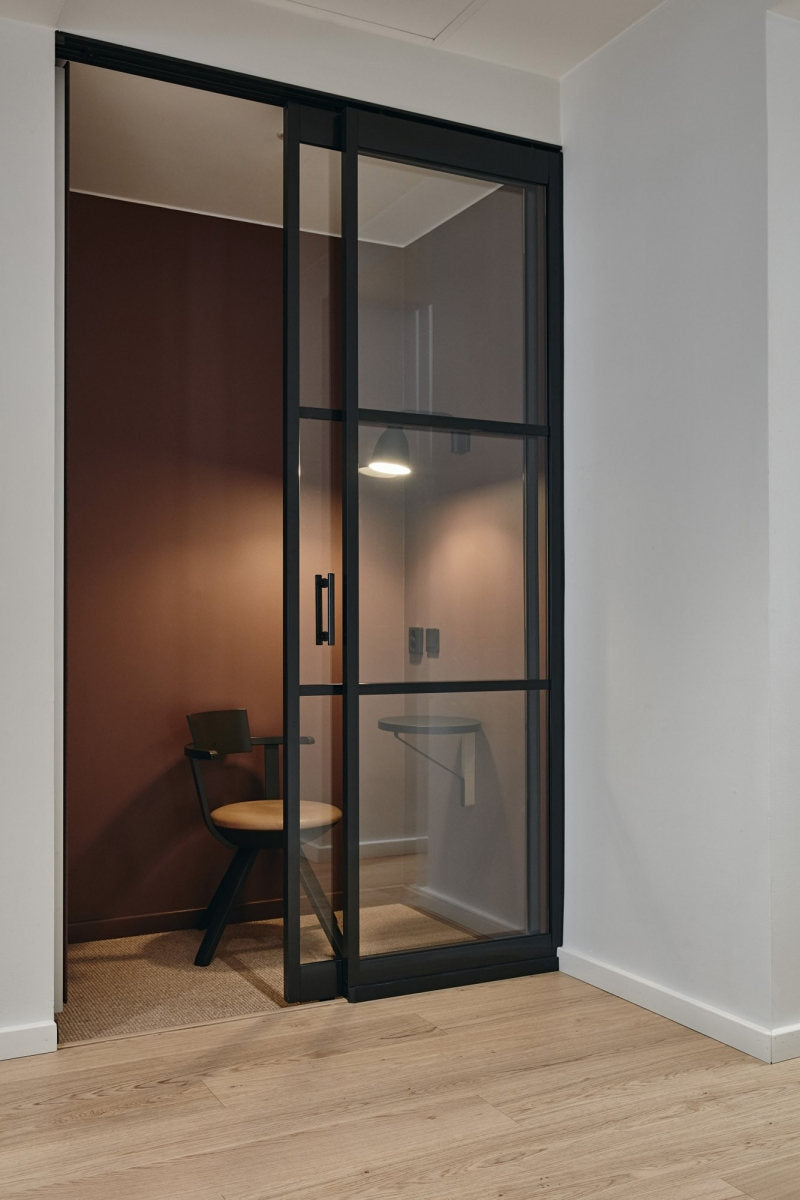 Modern interior with a glass sliding door separating two rooms.