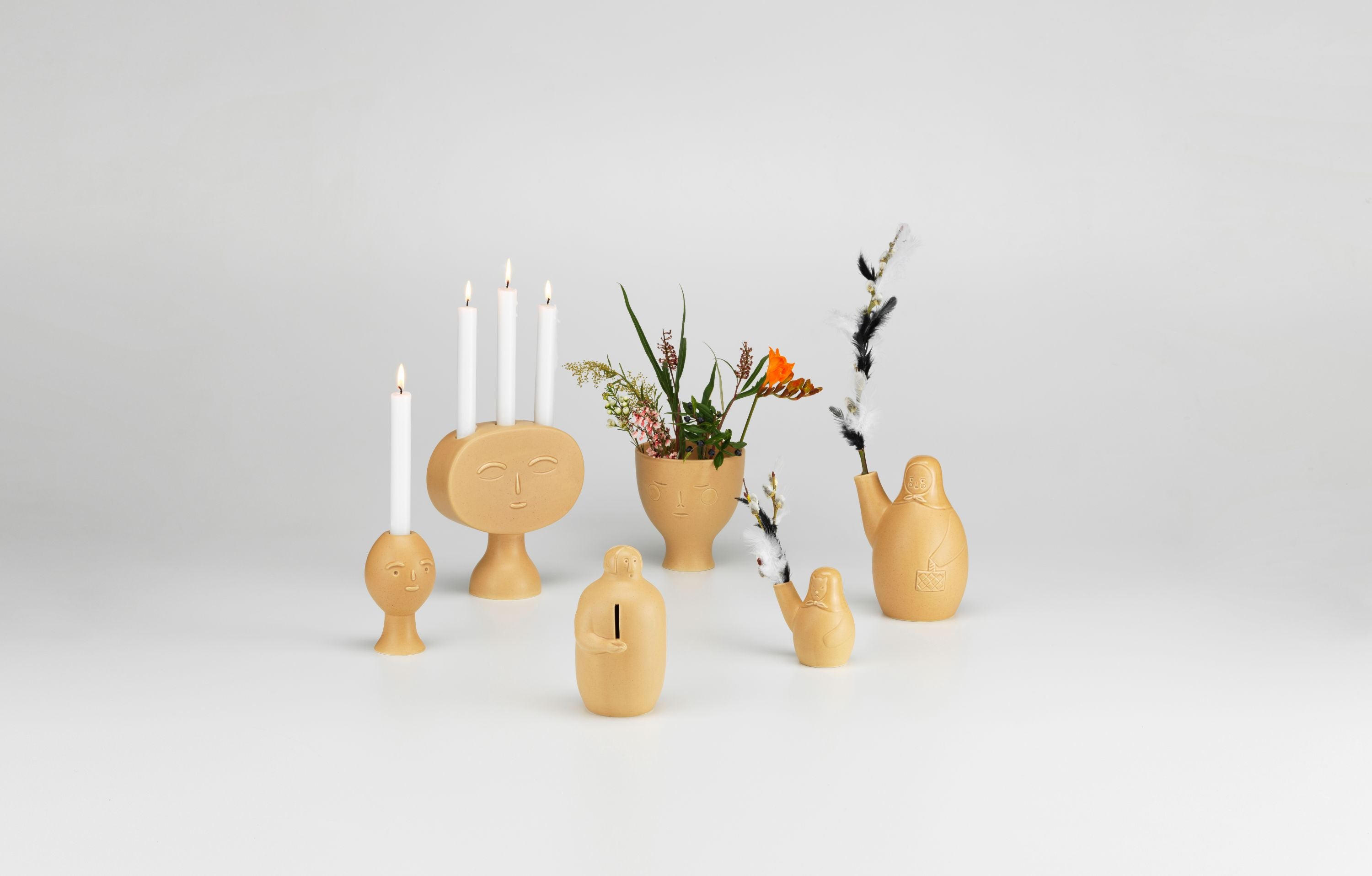 Set of wooden candle holders and vases on a light gray background