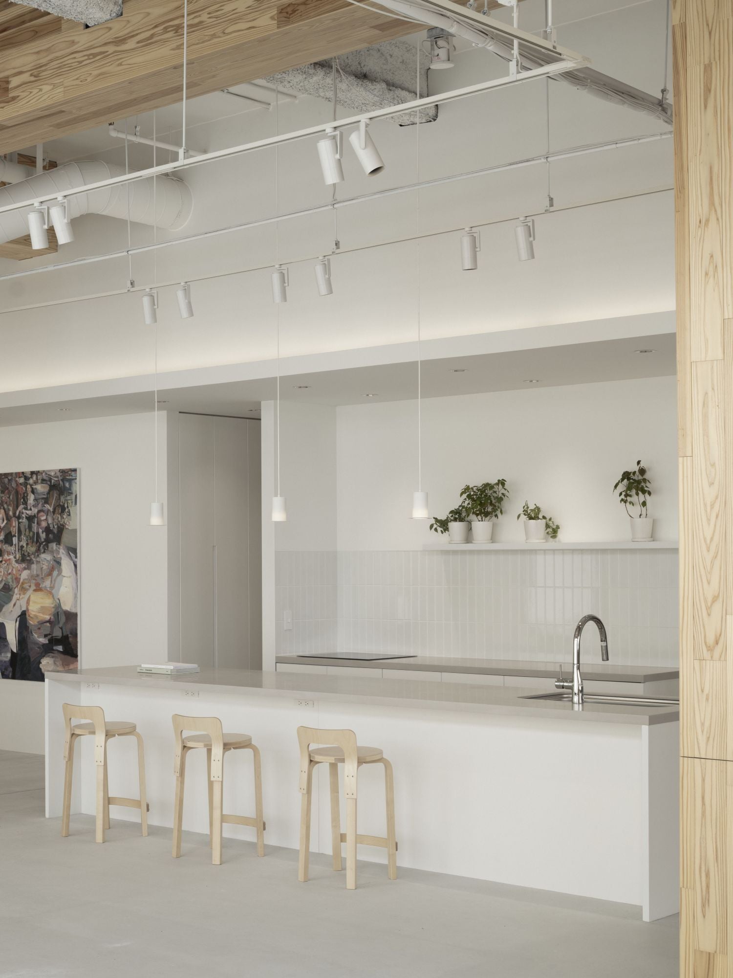Modern kitchen with white island, bar stools, and wooden accents.