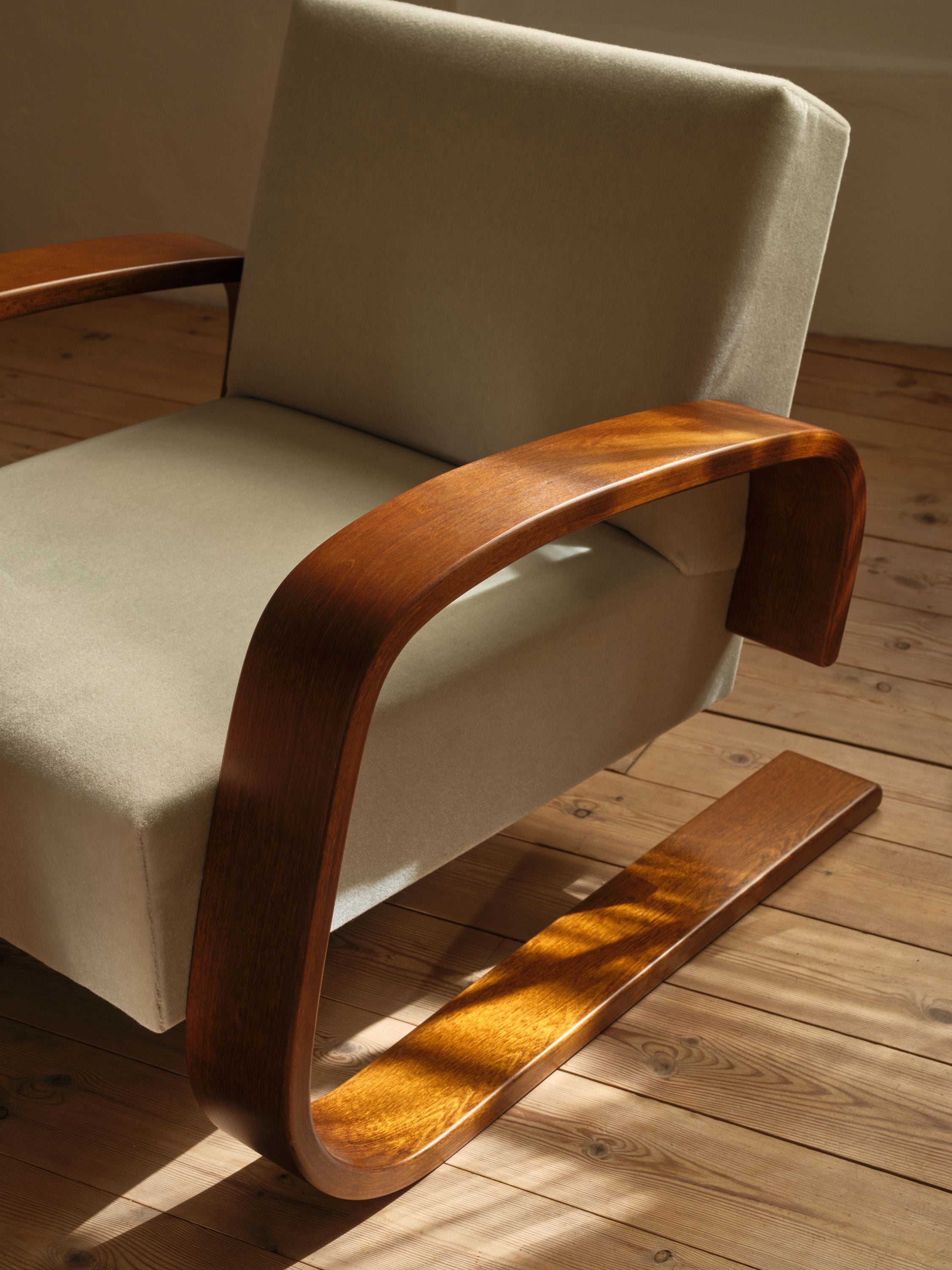 Chair with wooden armrests and legs on a wooden floor