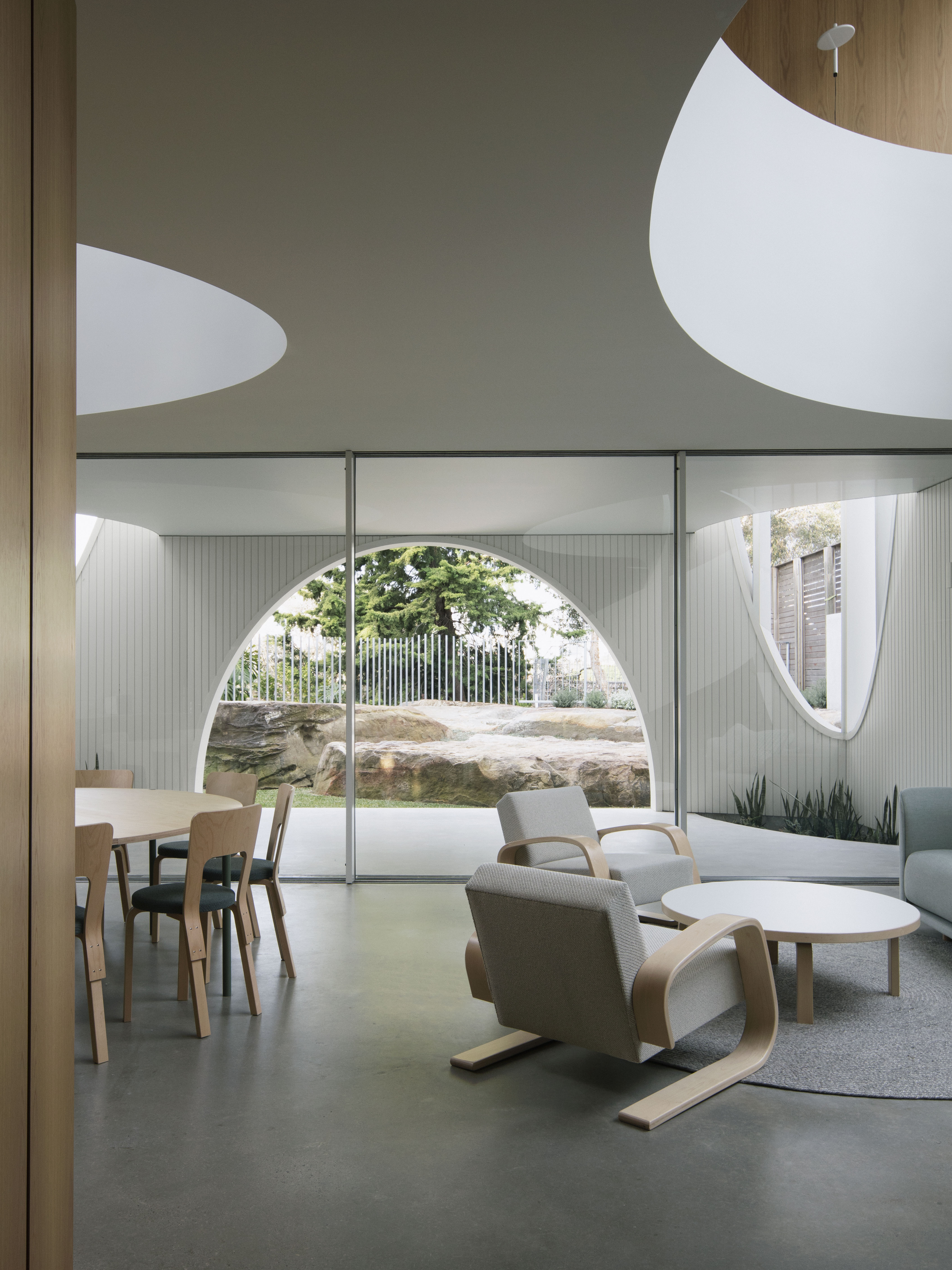 Modern interior design with chairs, tables, and large windows.