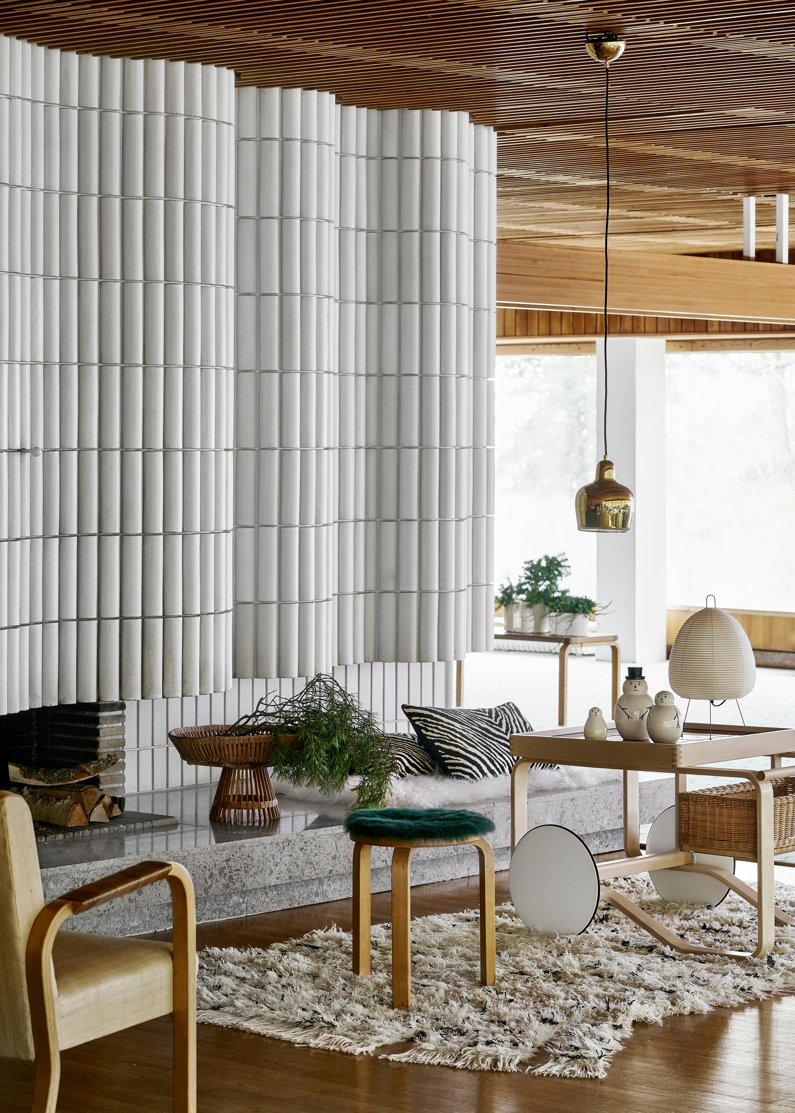 Modern living room with white textured wall, wooden furniture, and decorative elements.