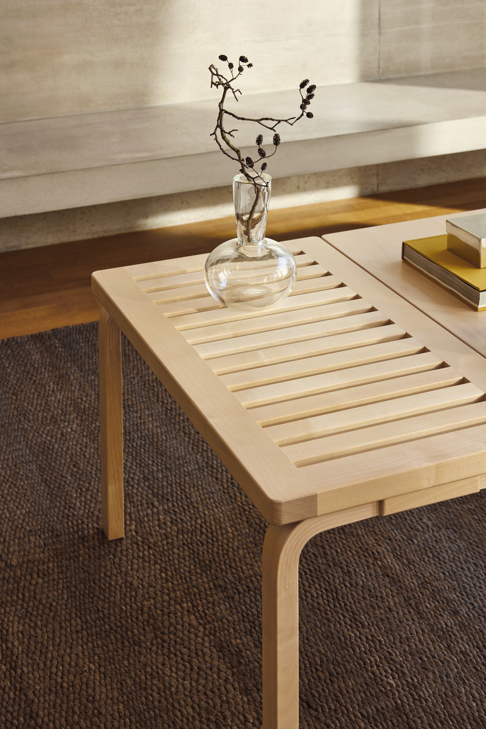 Wooden coffee table with a vase and decorative item in a modern interior setting