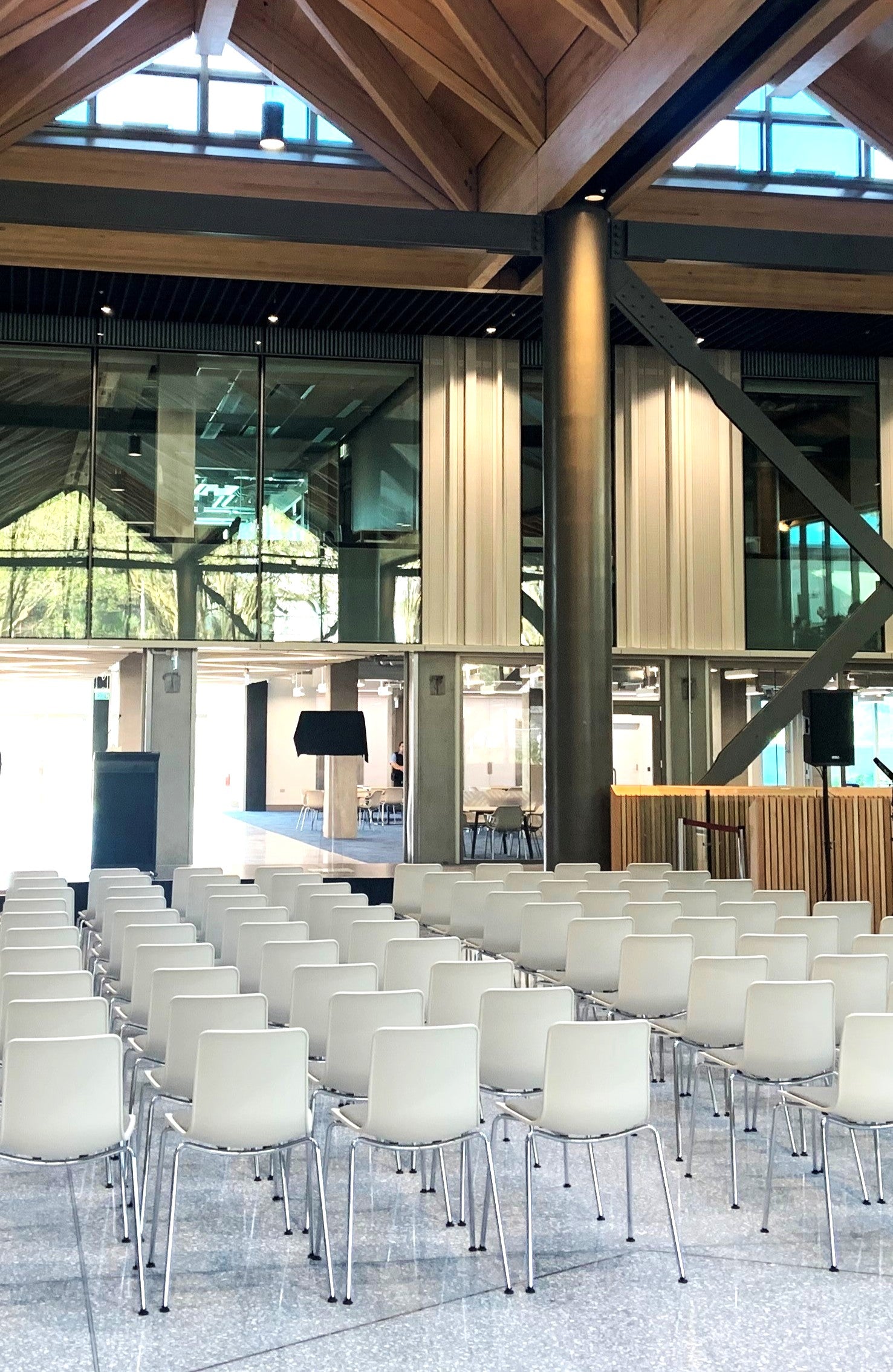 Modern conference room with white chairs and large windows.