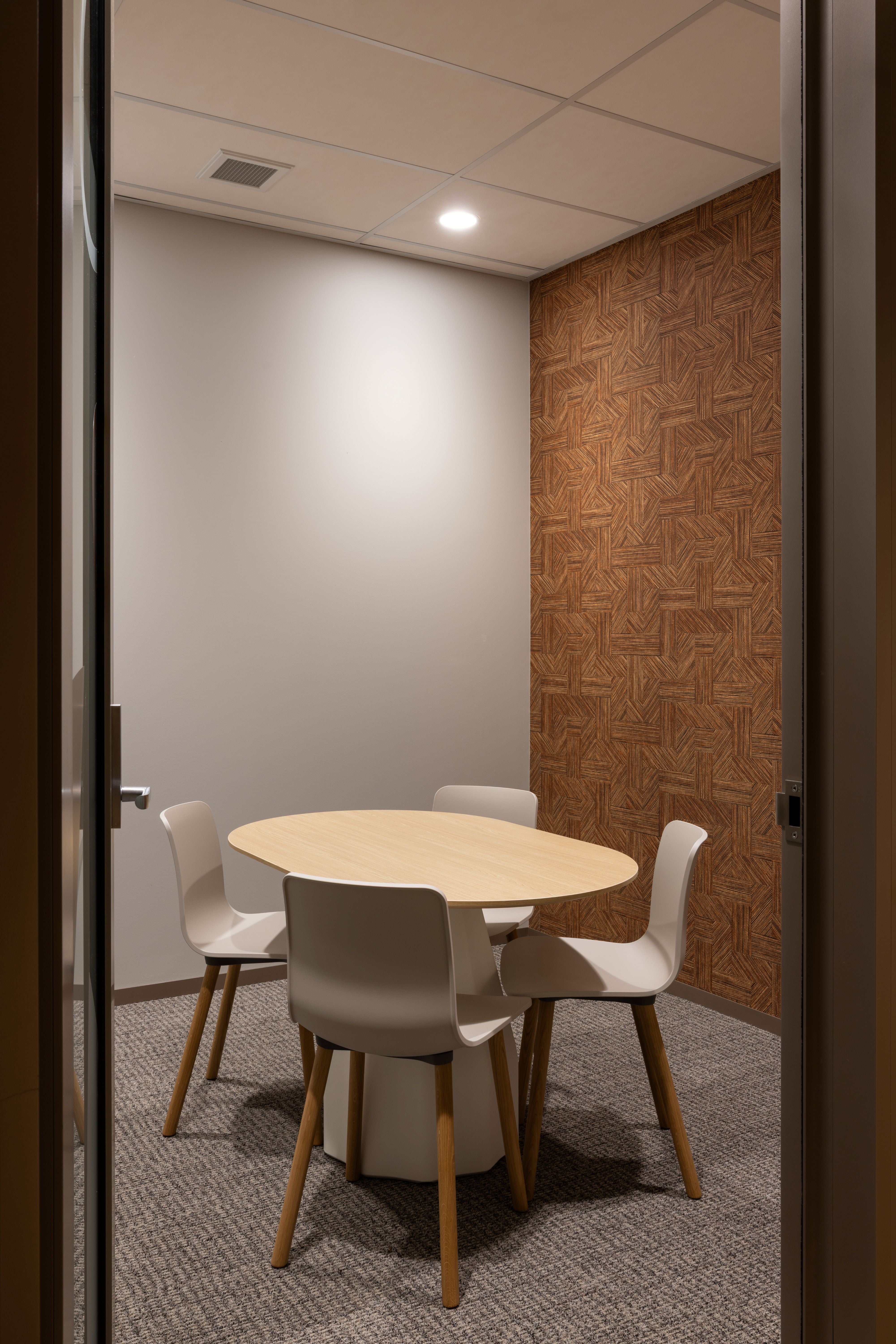 Modern office meeting room with a round table and chairs.