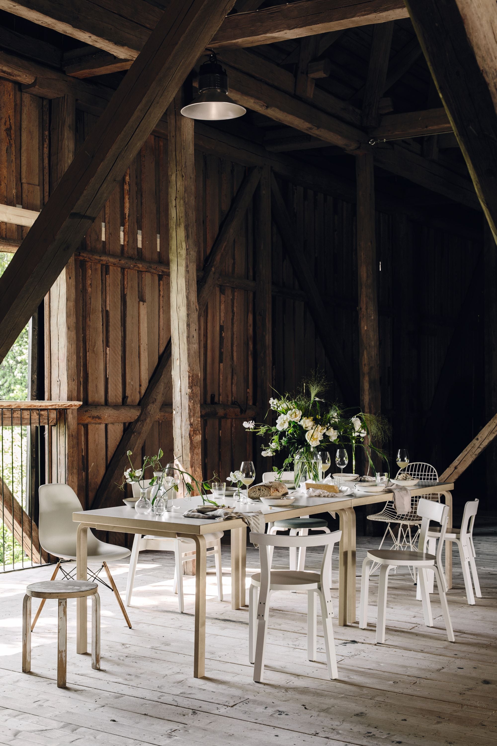 Dining area in a rustic wooden barn with a table set for a meal.