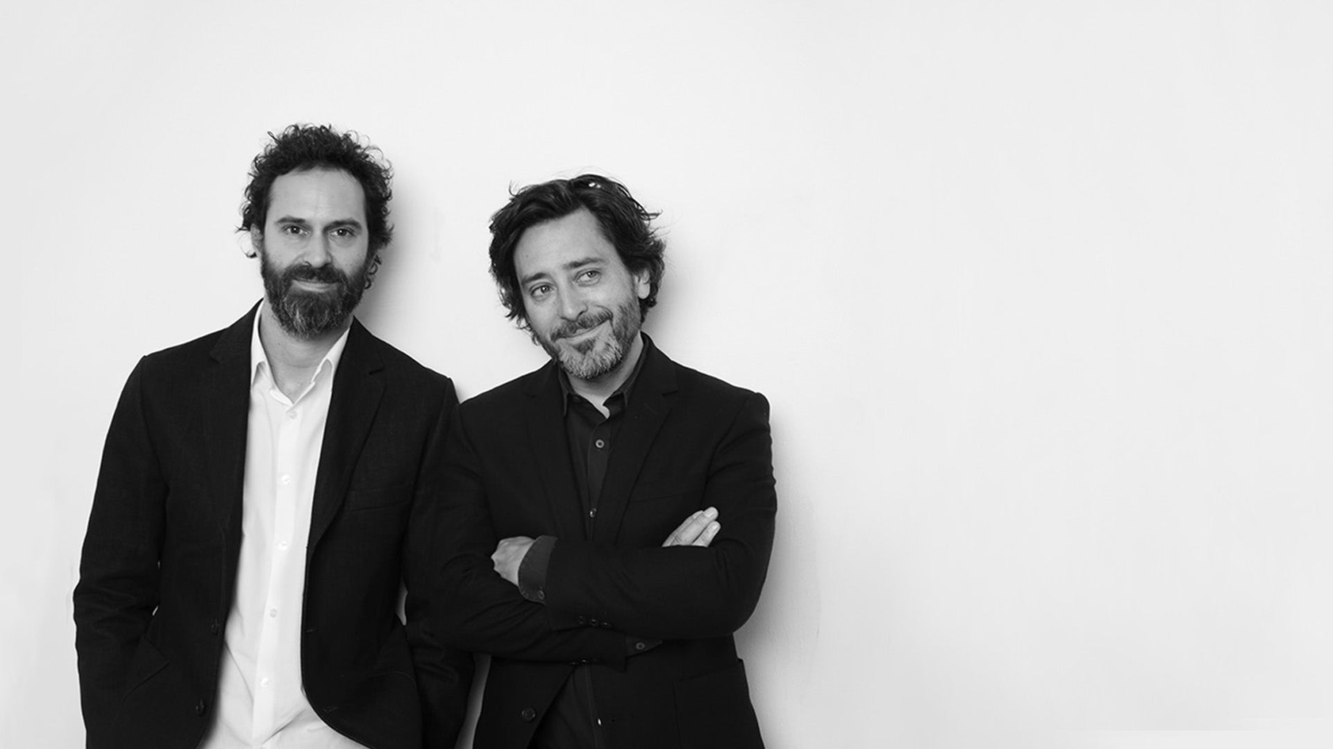 Two men standing side by side against a white background