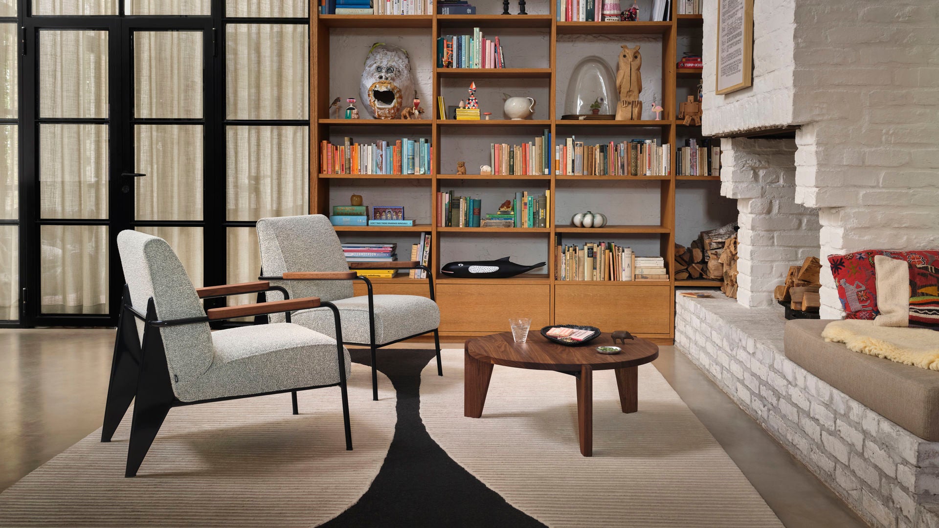 Modern living room with bookshelf, chairs, and a coffee table.