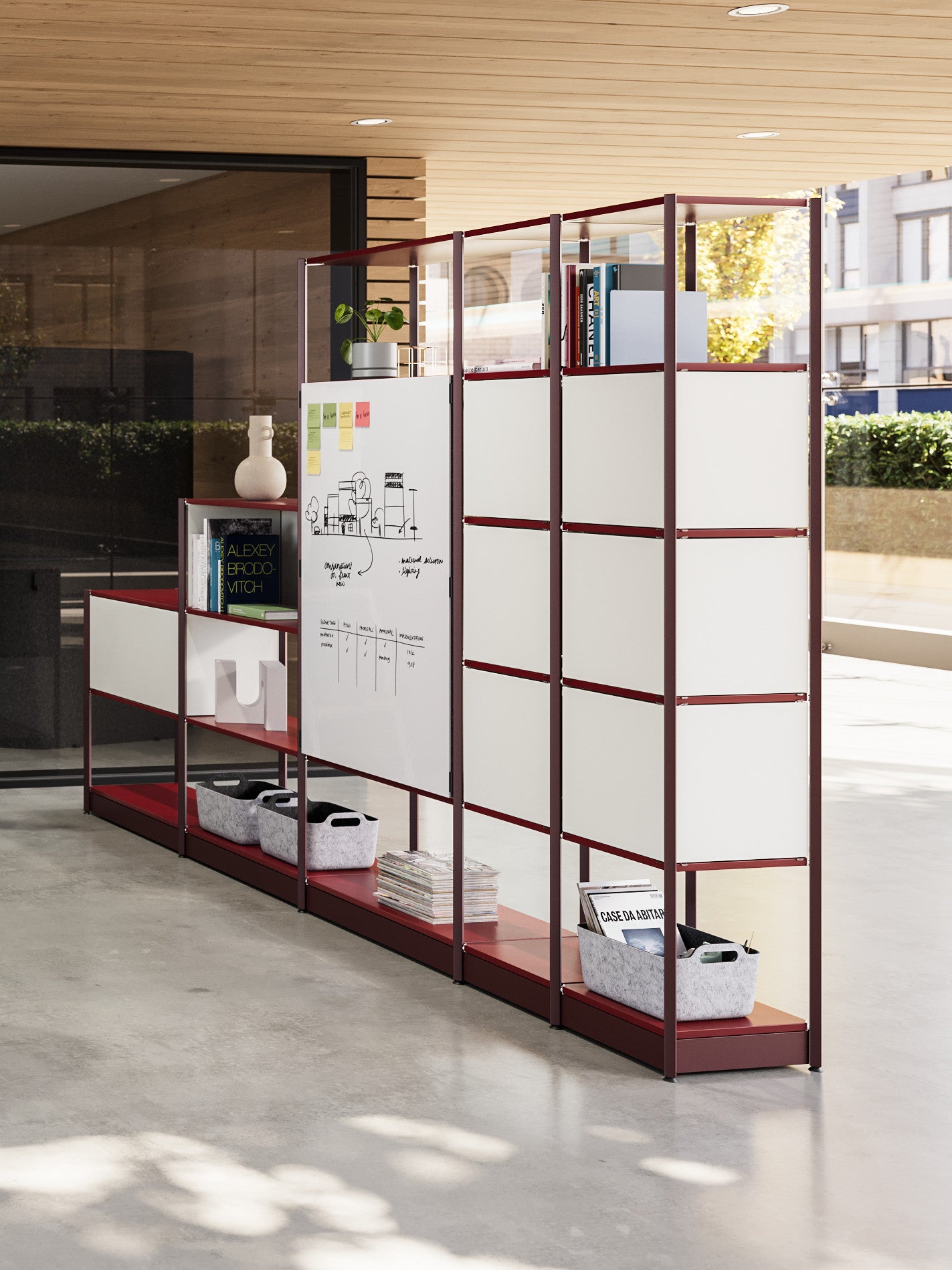 Modern office partition with shelves and whiteboard in a bright room.