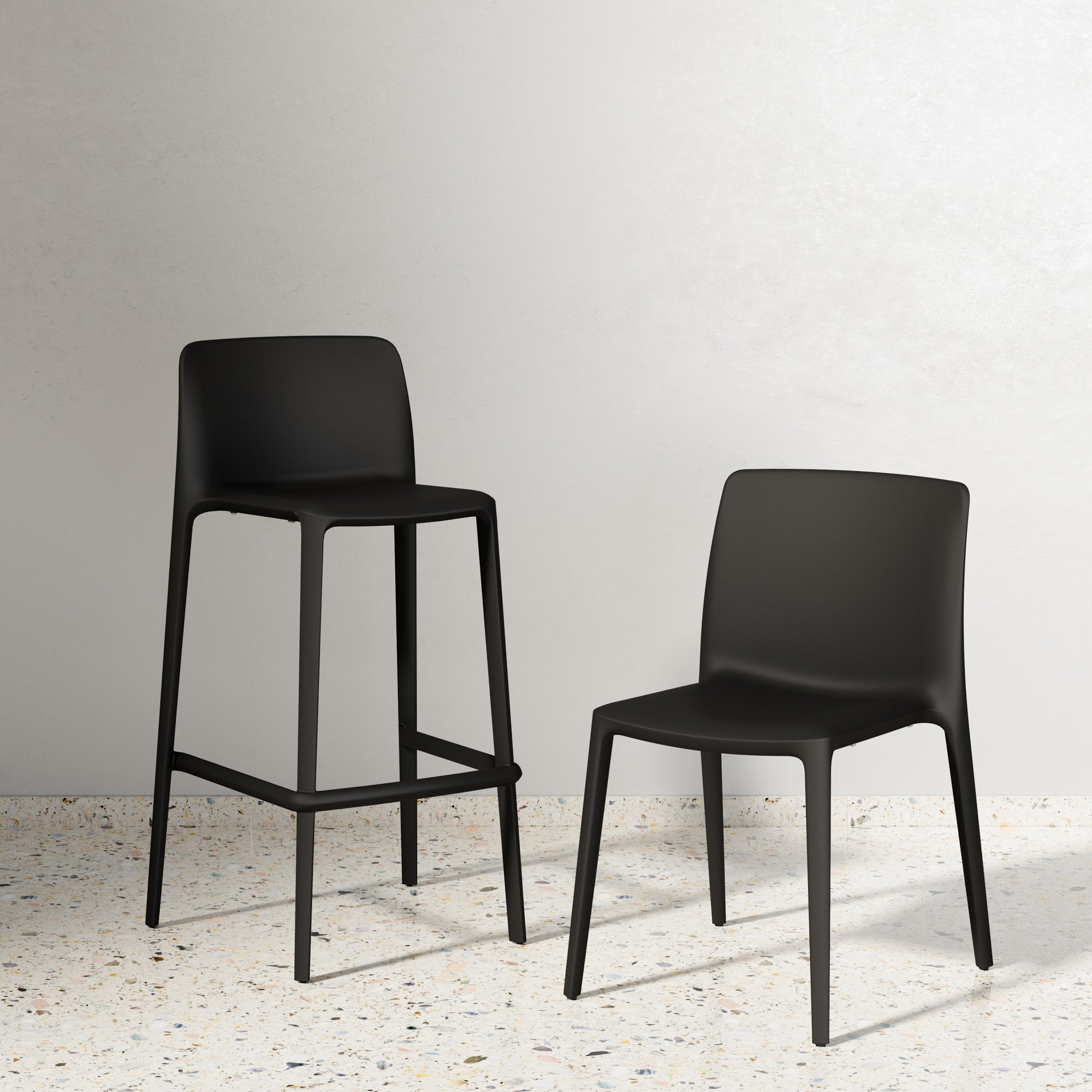 Two black chairs on a light gray floor with a neutral background