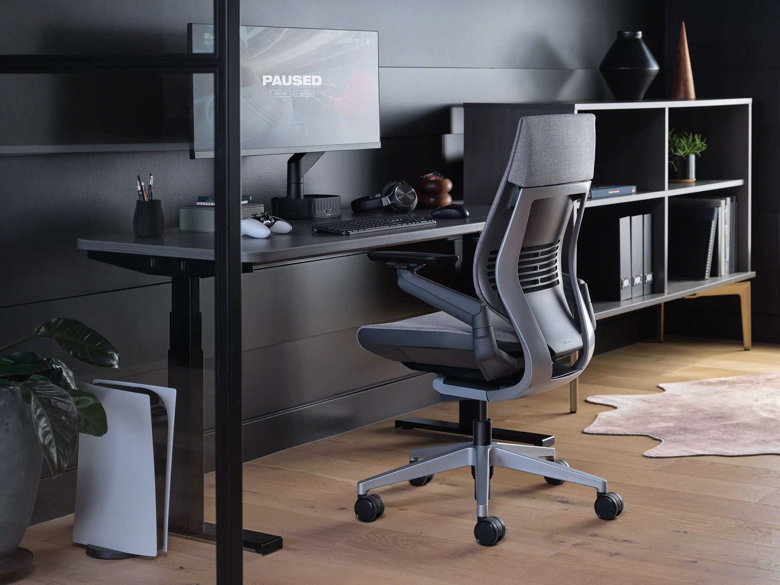 Modern office chair in front of a desk with a computer setup.