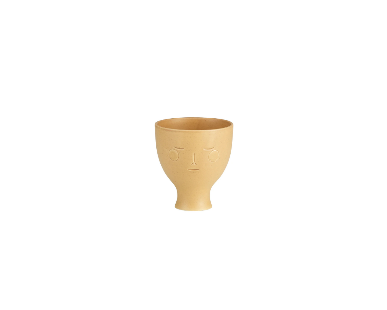Beige ceramic cup with face design on a white background