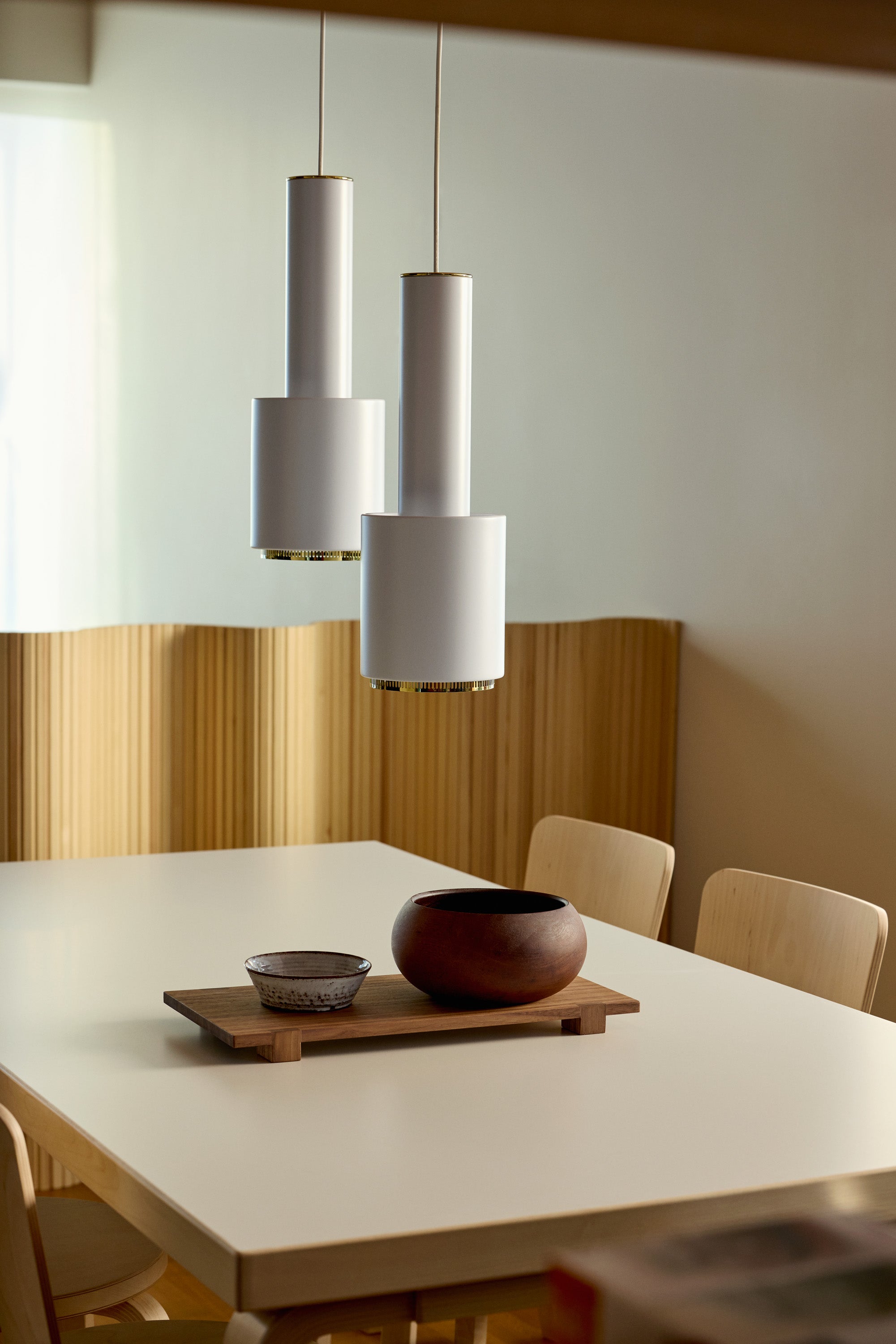 Dining area with a table, chairs, and modern pendant lights.