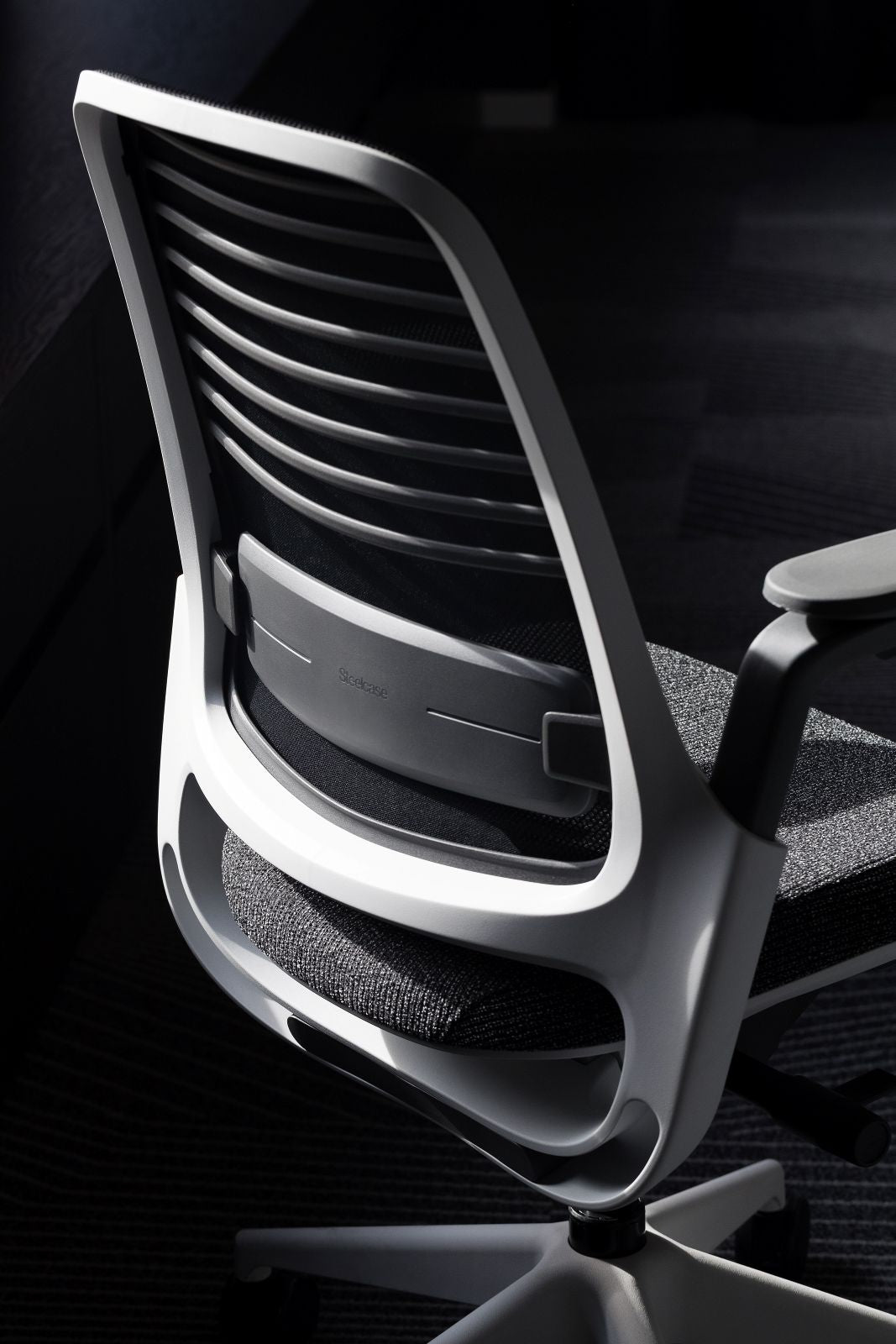 Modern office chair with a black and white color scheme on a dark background