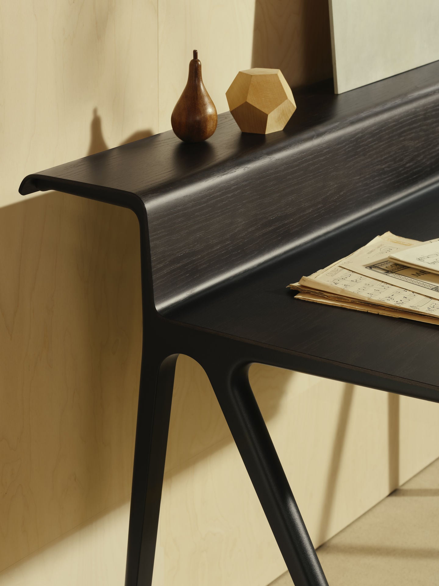 Black desk with decorative items on a beige wall background