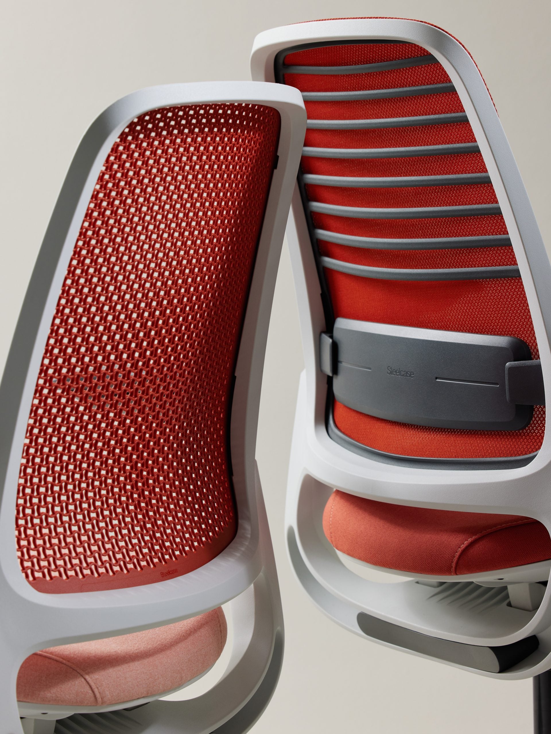 Red mesh office chair with white frame on a light gray background